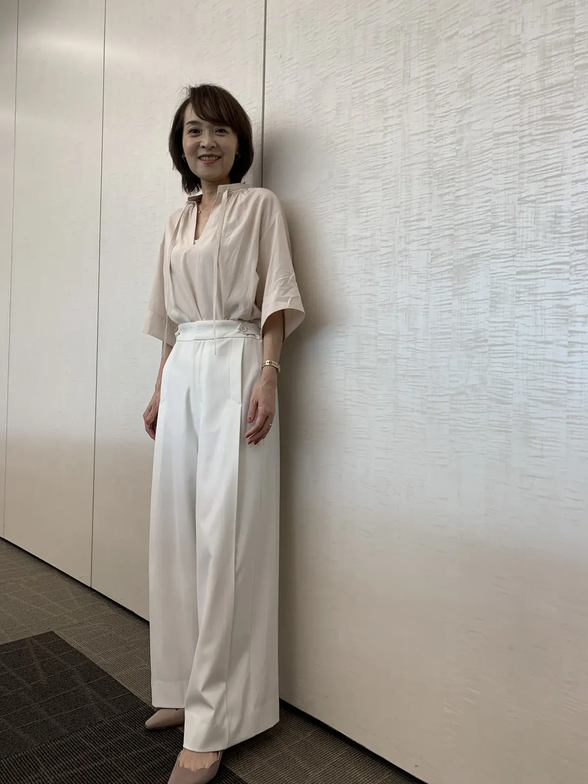 優美なセミワイドパンツ（白）を着用した女性