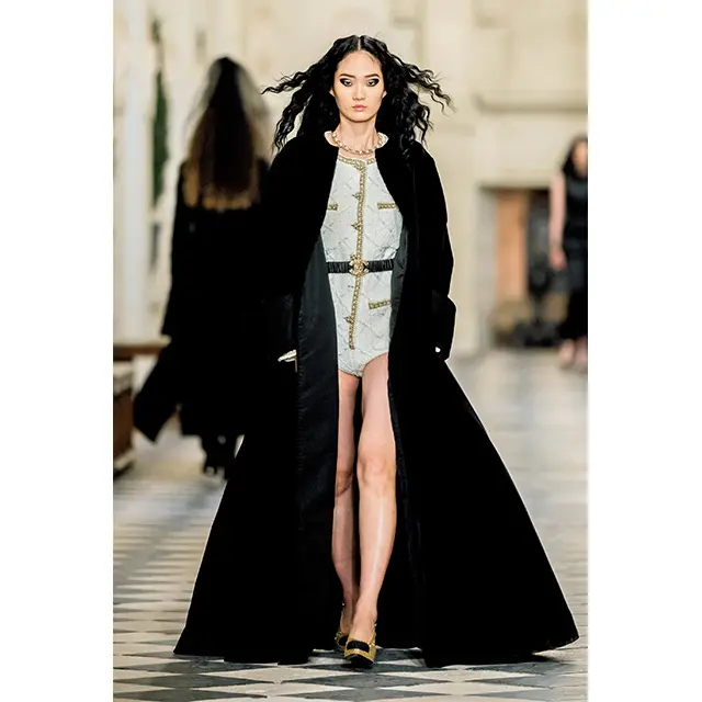 中世をイメージさせ るブラックベルベット のマキシ丈コートのインには、画期的なツイ ードのボディスーツが