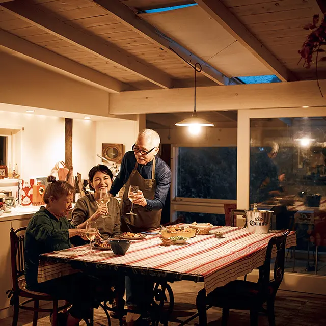 本日のメイン料理、パエリアを 堪能する板谷さんと小暮さん夫 婦。ダイニングのテーブルも椅 子もパリの蚤の市で出会い、長 く愛用しているもの。奥がサン ルームになっている。