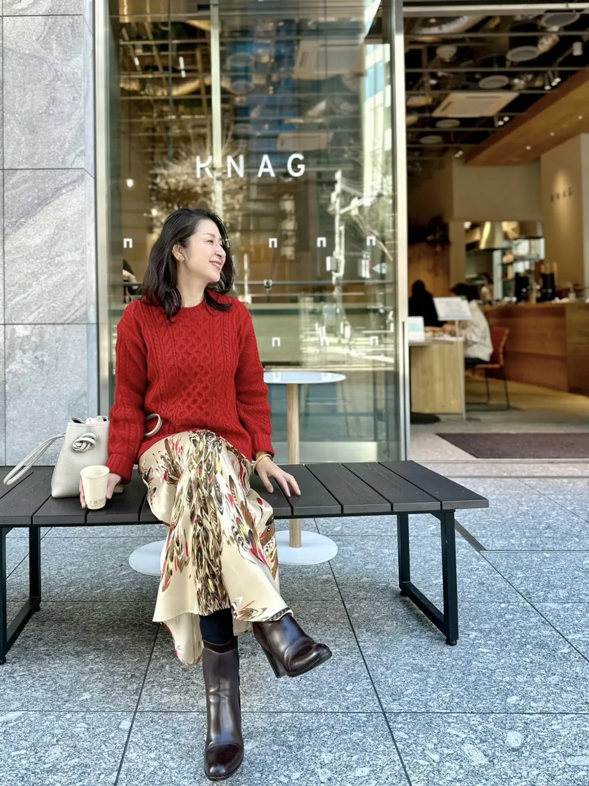 ユニクロケーブルニット、フェザー柄スカート、白バッグ、茶のショートブーツ