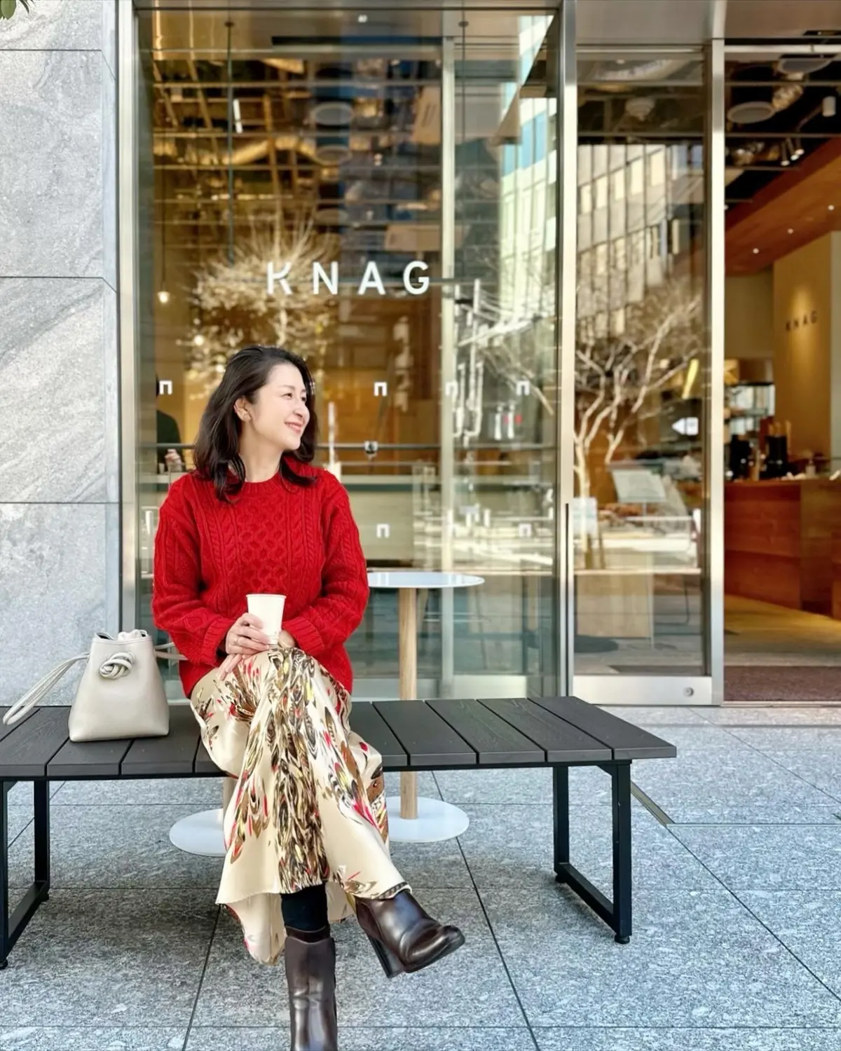 ユニクロケーブルニット、フェザー柄スカート、白バッグ、茶のショートブーツ