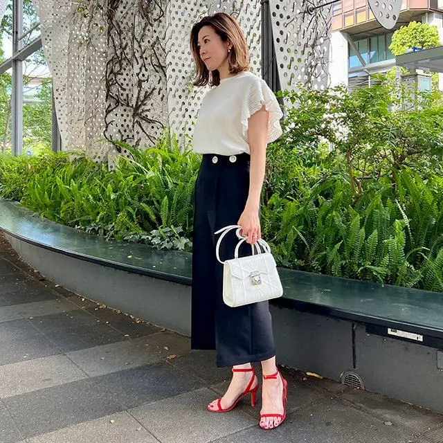 華トップスとエレガントなパンツで、モノトーンスタイルを優し気な表情に