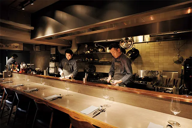 オープンキッチンに面したローカウンター。手前が廣瀬シェフ。