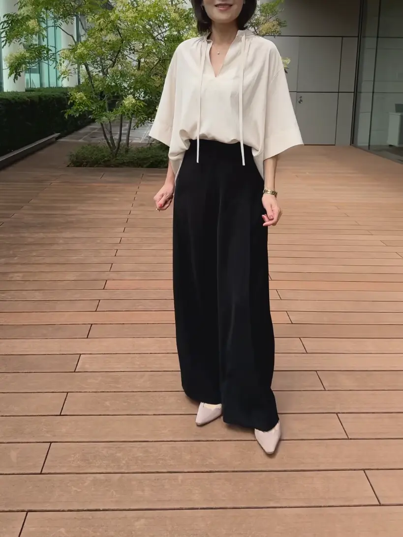 小柄でもスタイルアップが叶う優美なセミワイドパンツを着た女性。