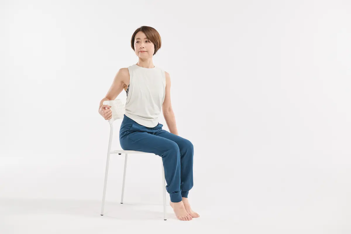 デスクワークの合間に 体の前側を伸ばすストレッチ 椅子に座って、背もたれを片手でつかんで肘を固定する