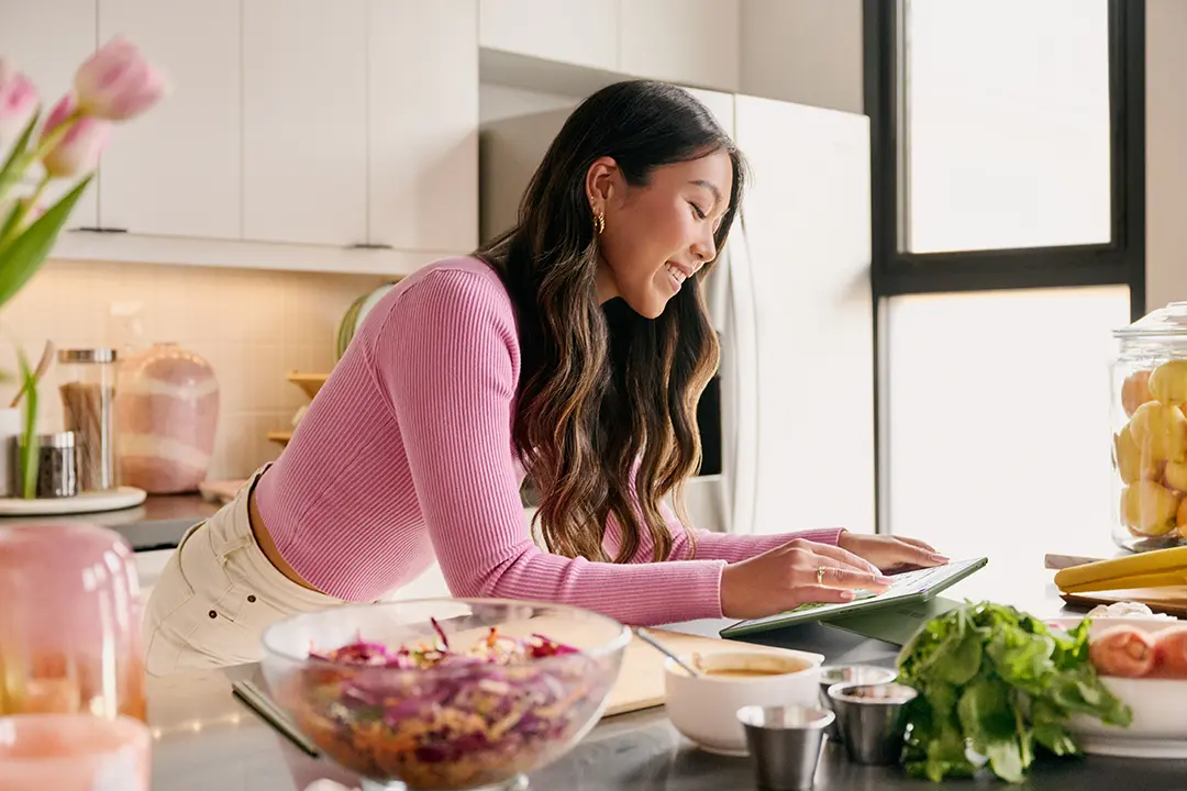 キッチンでサーフェイスを操作する女性