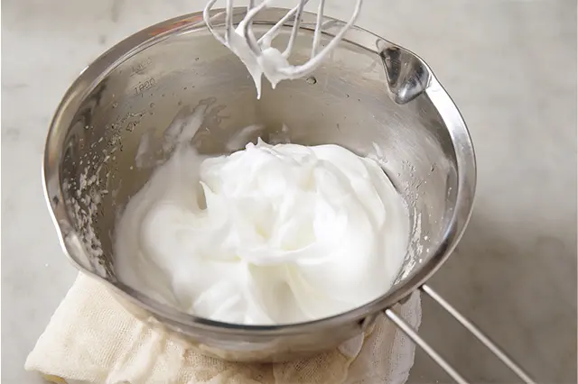 別のボウルで卵白と粉砂糖を泡立てて硬いメレンゲを作る。