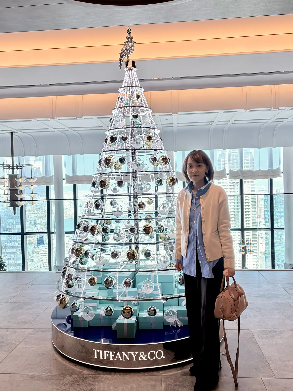 ウォルドーフ・アストリア大阪　Tiffanyのクリスマスツリーの前で記念撮影をする女性
