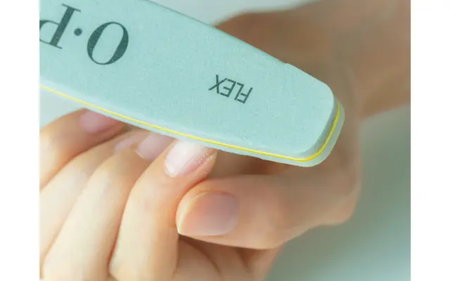 爪磨きを爪の表面にさっとすべらせ、表面がうっすら白くにごるまで削る。