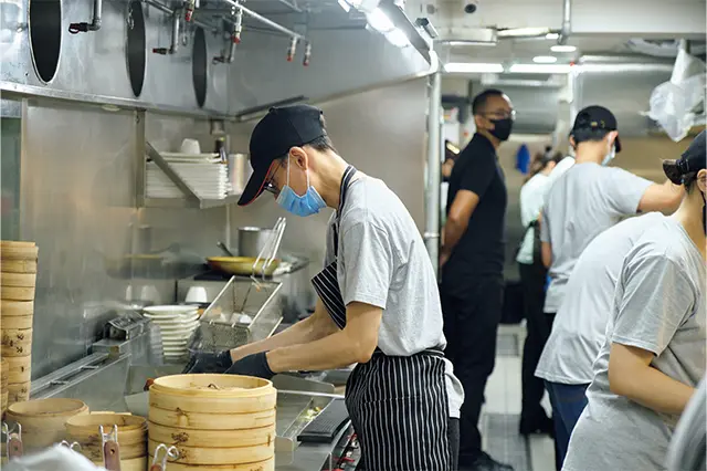 ガラス張りのキッチンからは、新ベ ジ料理にふさわしくキャップにTシャ ツのユニフォーム姿のスタッフたちが