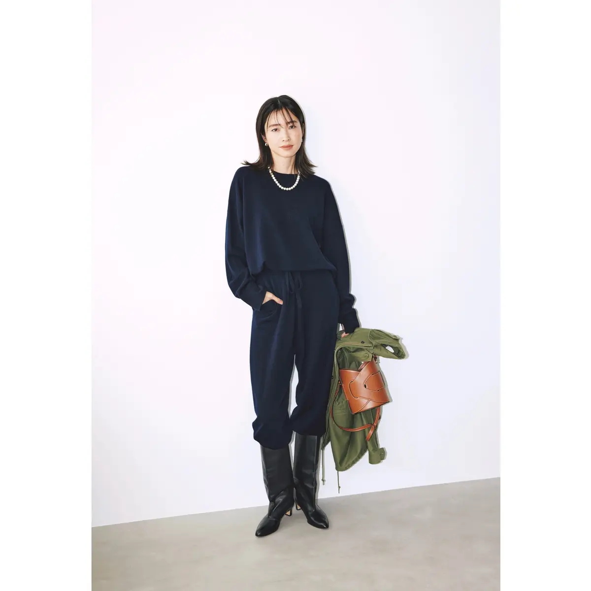 ネイビーニットのプルオーバーとパンツのセットアップに、黒ブーツを合わせたコーディネート　モデル・絵美里