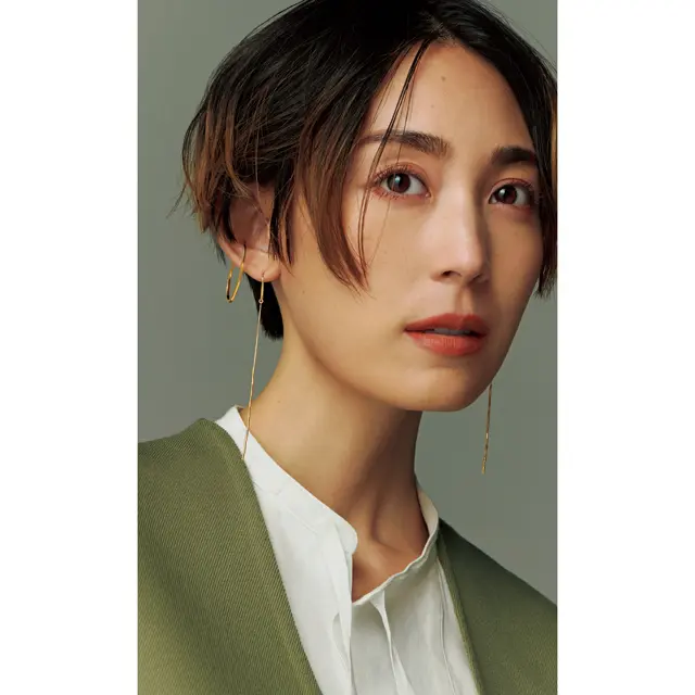 ゴールドのフープモチーフのイヤカフをしたLIZA