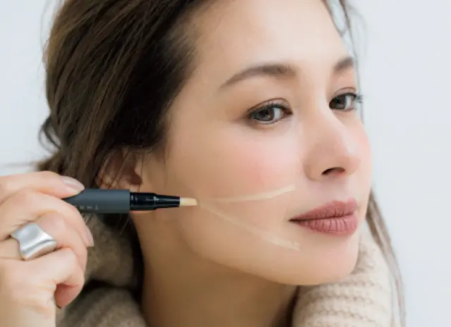 黄色のコンシーラーをほうれい線から真横に、さらに口角下から斜めに入れなじませる