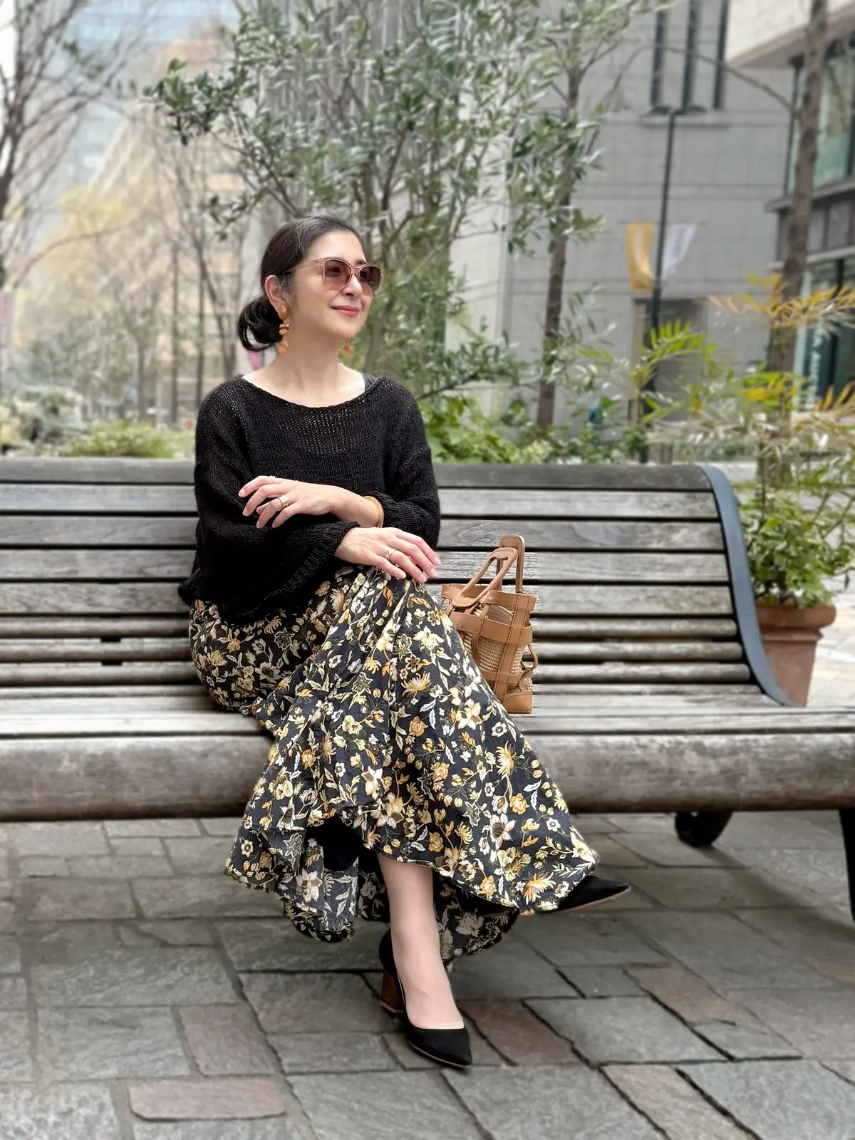 黒のサマーニット、黒の花柄スカート、キャメルバッグ、黒のパンプス