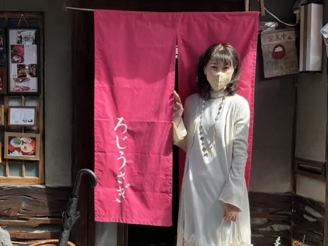 ろじうさき　暖簾の前で