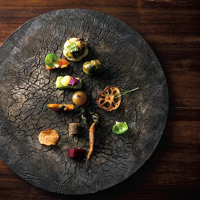 夕食の最初のひと皿は、道産さつまいも、鱒の燻製、芽キャベツ、玉ねぎの黒酢漬けほか、秋の野菜をふんだんに。器はにしだゆか作。