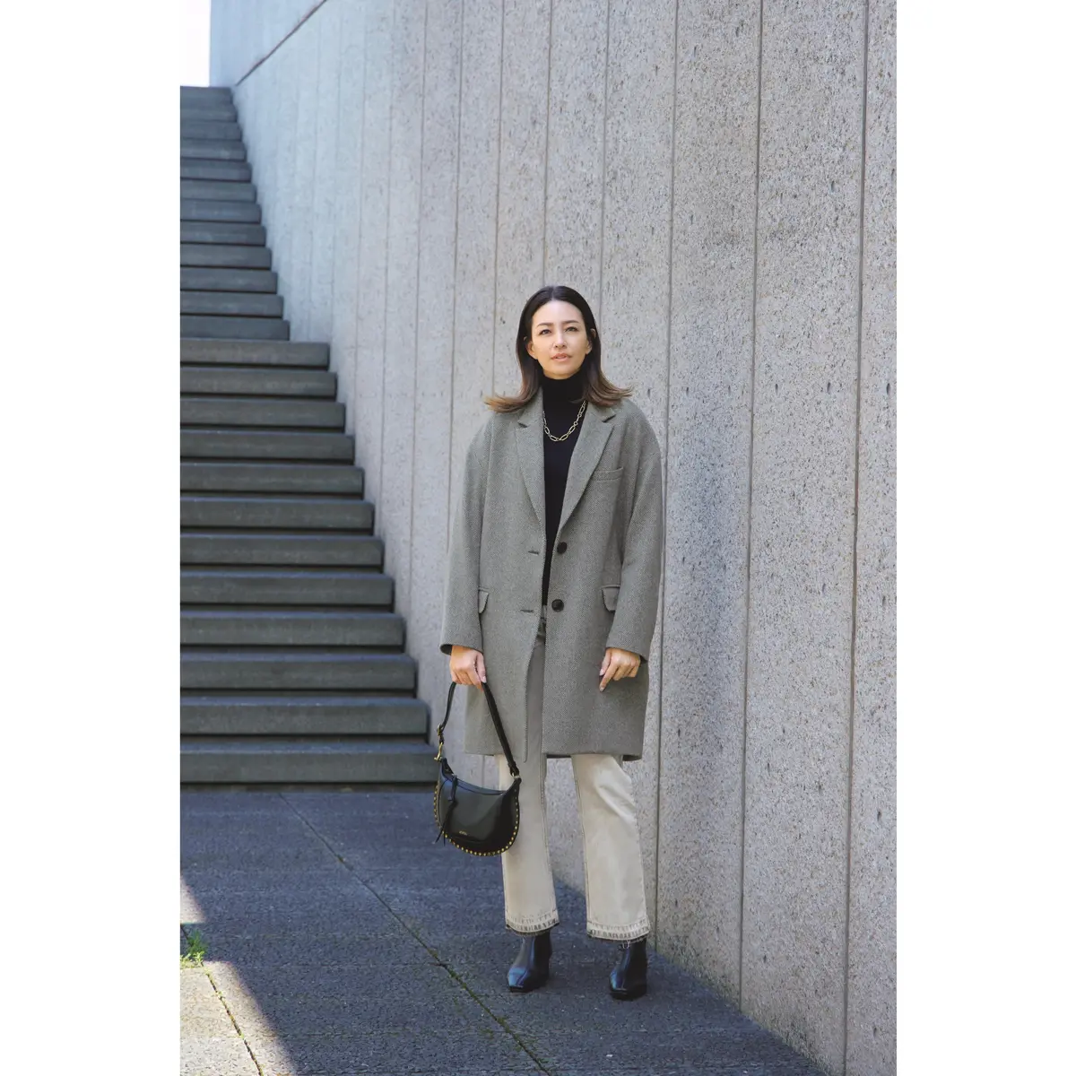 グレーコートと黒タートルネックトップスと白パンツのコーディネート　モデル・RINA