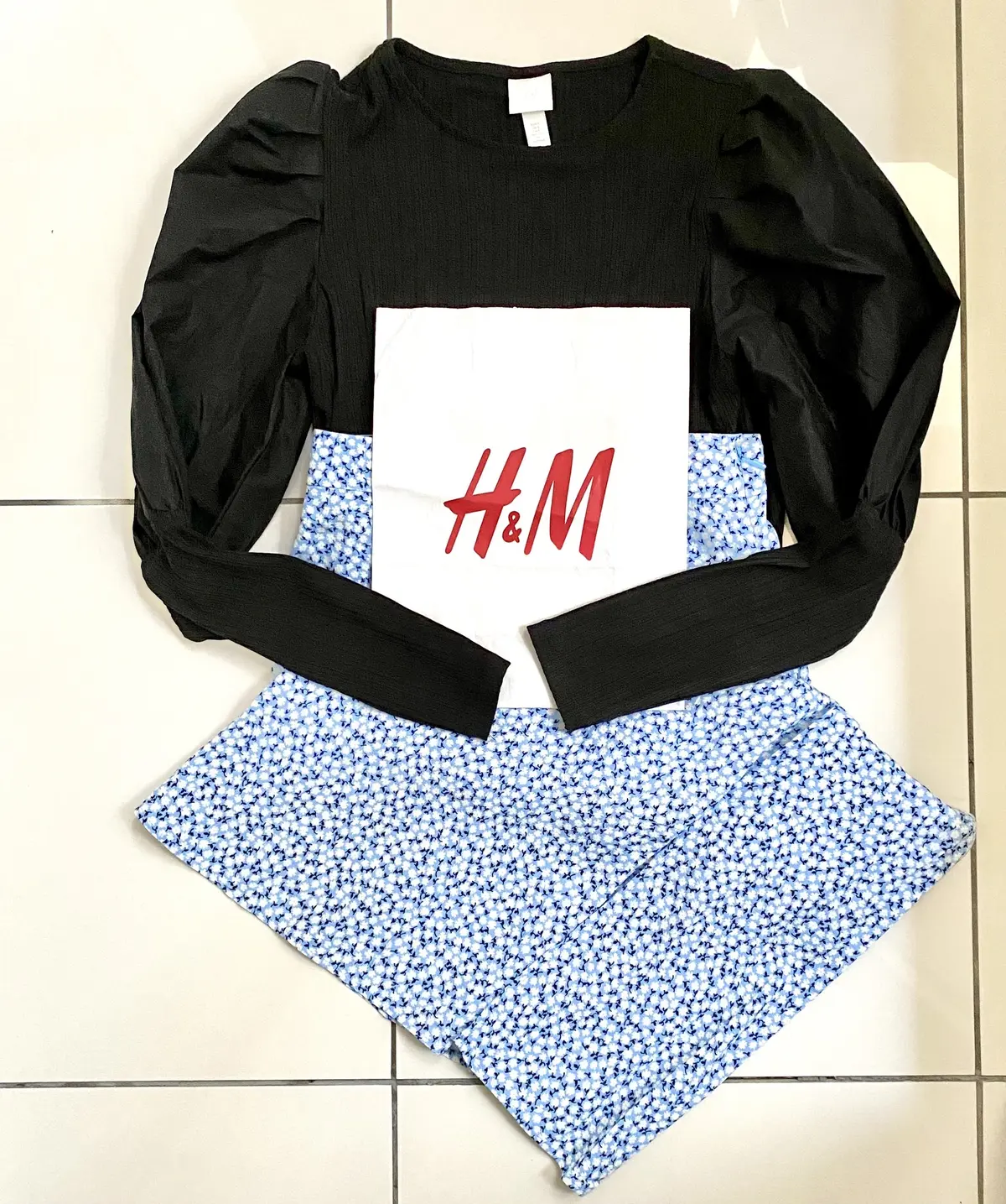 黒のトップスとブルー系小花柄スカート