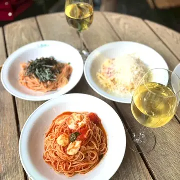 新宿御苑ラ・ボエムで楽しんだランチ。パスタ3種と白ワインをテーブルに並べた写真。同期ランチ会で味わったイタリアンランチの一コマ。