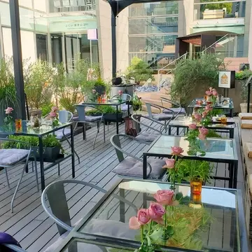 各テーブルに薔薇の花が飾られた気持ちよいテラス席。