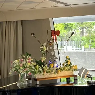 船内エントランスのらせん階段と花のディスプレイ。優雅な空間が広がる