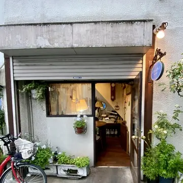 荻窪の住宅街にひっそりと佇むプチグレースの外観。木の扉と小さな植栽が印象的