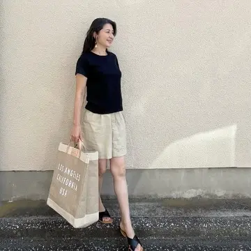 黒Tシャツ、ベージュのショートパンツ、黒サンダル、麻の大きめエコバッグ