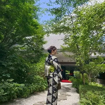 雅叙園中庭に立つ浴衣姿の女性の写真。緑とのコントラストが美しい