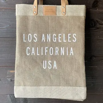 麻の素材に白の英字ロゴが描かれた大きめエコバッグ