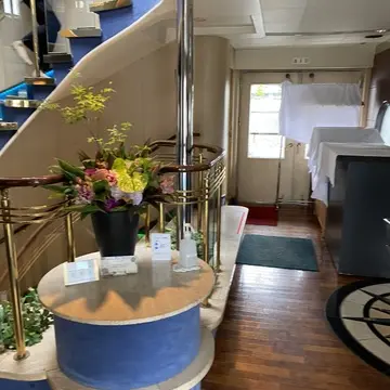 船内エントランスのらせん階段と花のディスプレイ。優雅な空間が広がる