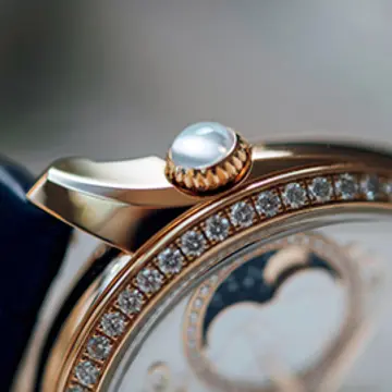 2時位置に大胆にあしらわれたリュウズには、カボションカットのムーンストーンまたはローズカットのダイヤモンドをセット。月の光を宿したような優しい光沢を持つムーンストーンは、フェミニティを象徴する神秘的な