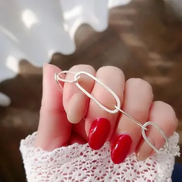 赤とミルキーベージュのネイル。LE ZEPHYR(ルゼフィール)さんのレースのブラウス(22,000円)とシルバーのブレスレットを。