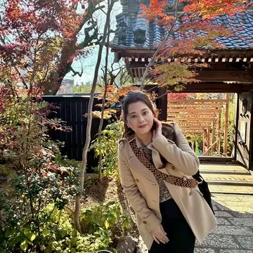早稲田・法輪寺の紅葉の境内で花手水を背景に撮影した女性の写真。秋の散歩、早稲田さんぽ、花手水が美しい寺院のフォトスポット