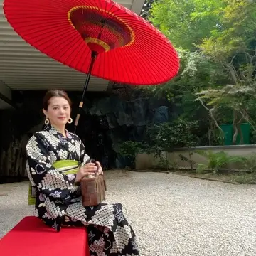 雅叙園の中庭の赤い番傘と浴衣姿の女性。