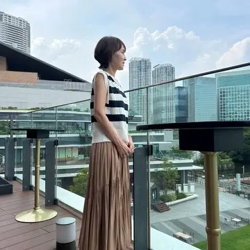 ウォーターズ竹芝を背景に海を眺める女性