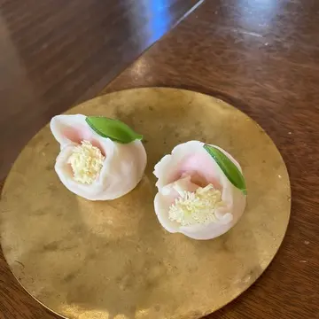 完成した上生菓子「こかたし（山茶花）」2つを金皿に盛り付けた写真。