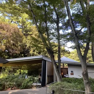 東京都庭園美術館に併設されたレストラン「TEIEN Restaurant comodo」の外観。緑に囲まれたモダンなガラス張りの建物。