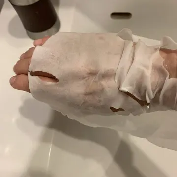 水分が残ったシートマスクを手に巻く