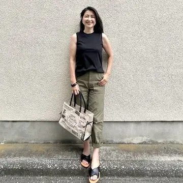 黒Tシャツ、カーキのベイカーパンツ、黒サンダル、エコバッグ