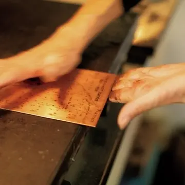 手のひらの外側を使って油膜を払うようにインクを落とす