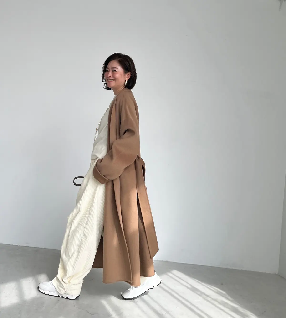 三尋木奈保さん ベージュロングコートの全身コーデ　コート・パンツ／CHIEKO＋　ニット／エイトン　バッグ／ザ ロウ　靴／ピエール アルディ