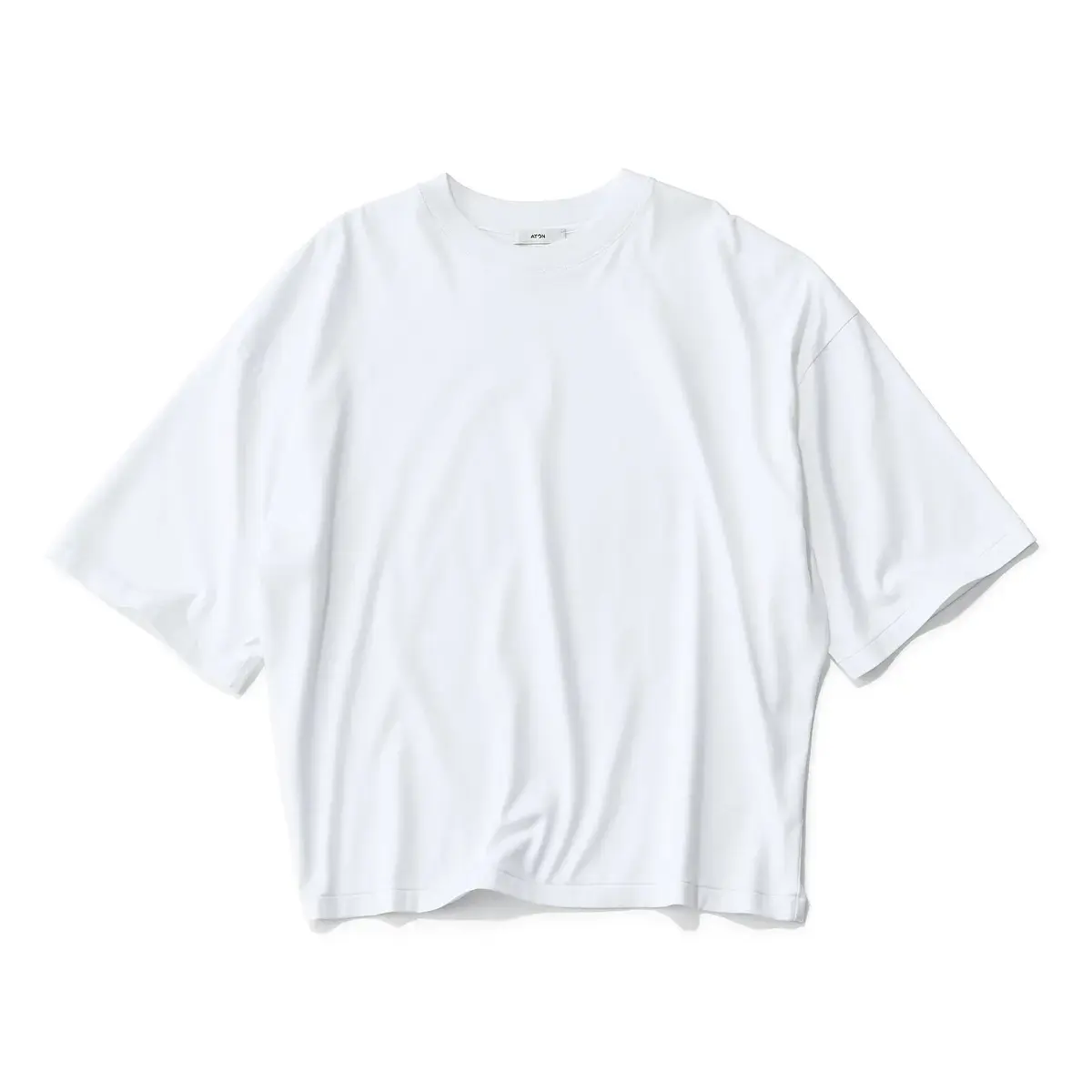 白いオーバーサイズのTシャツ。クルーネックで、ゆったりとした袖が特徴。AFFECTのロゴが胸元に小さくプリントされている。