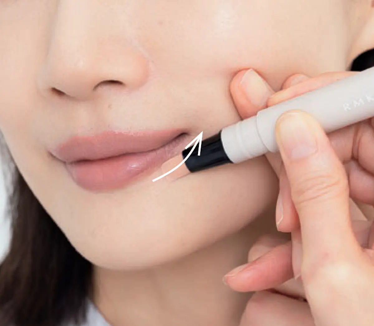 下唇から引き上げるように コンシーラーを一筆描き リップライナーを唇の縁に沿って塗る女性の手元