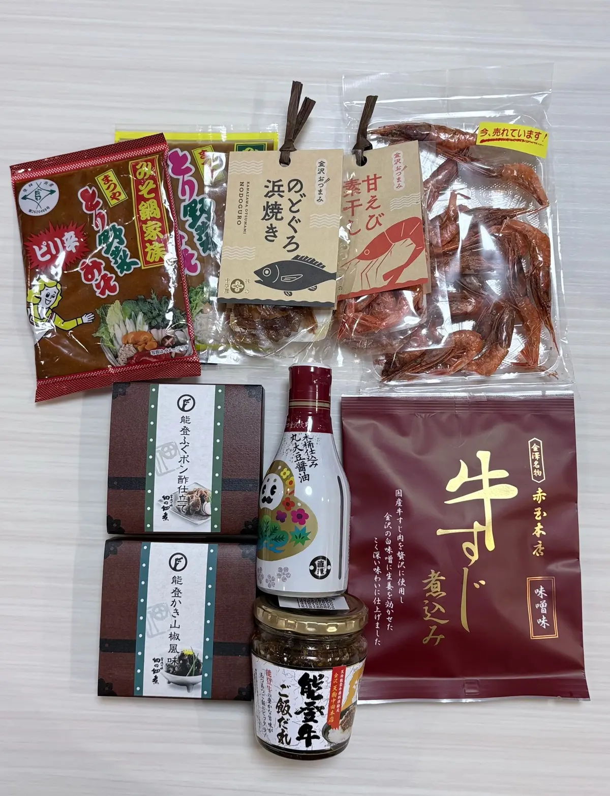 木屋高木店の箱に入った、6個の和菓子。白、灰色、茶色の丸いお菓子が、箱の中で整然と並んでいる。箱の内側には、緑色の紙の説明書が添えられている。