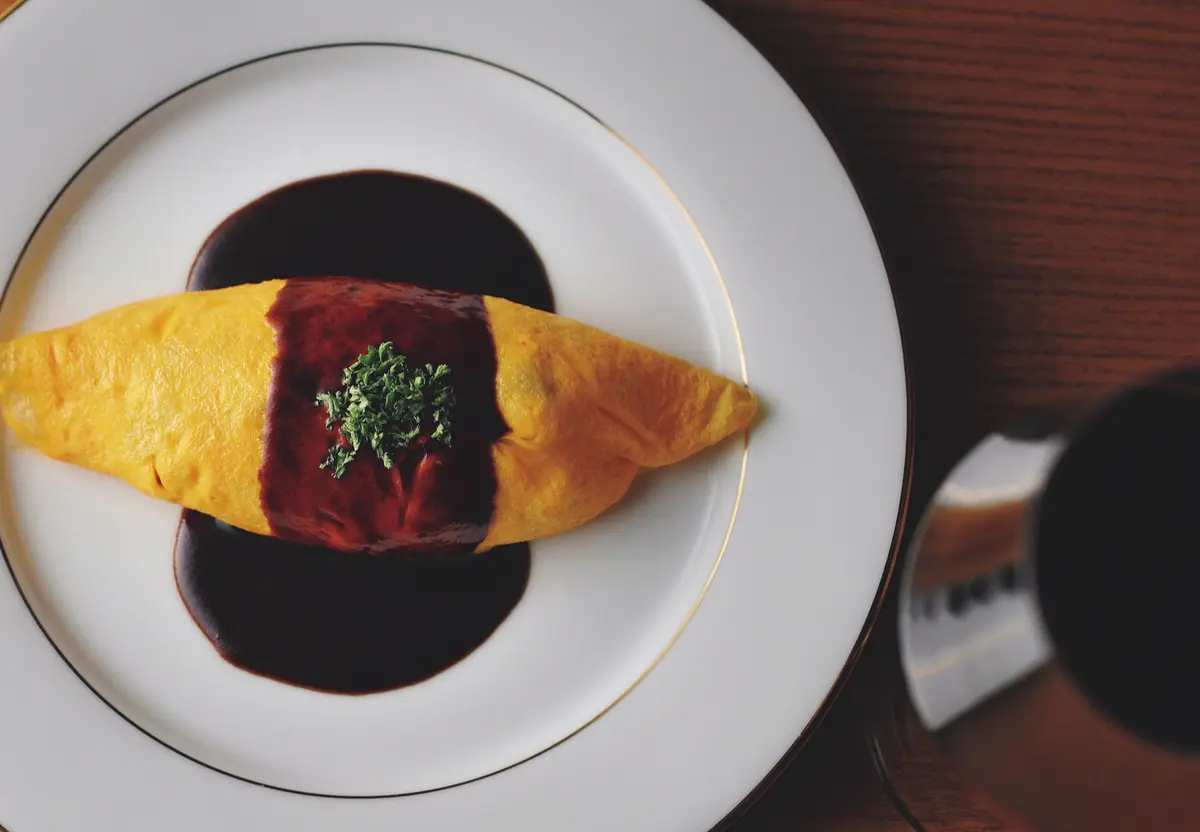 『洋食 レストラン marronnier（マロニエ）』宇都宮市「卵明舎」の卵 を生かした「磨宝卵のオムライス」。 写真は7,700円のコースで供されるミ ニサイズ。フルポーションはアラカル トで￥2,420。野菜の食感を残したチ キンライスにも洗練を感じる