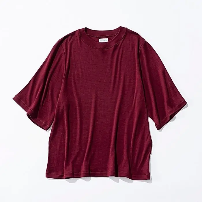 深紅色のクルーネックTシャツ。ゆったりとしたシルエットで、袖は短め。平らな背景に置かれ、正面から撮影されている。