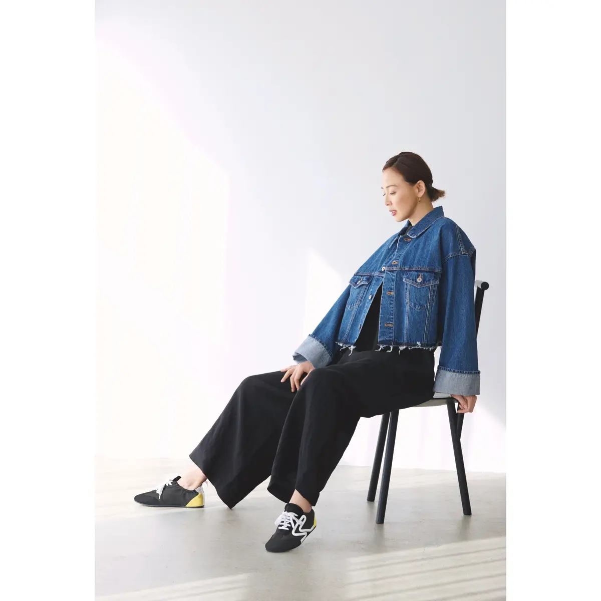 ブルーデニムのジャケットに黒パンツをと黒スニーカーを合わせたコーディネート　モデル・SHIHO