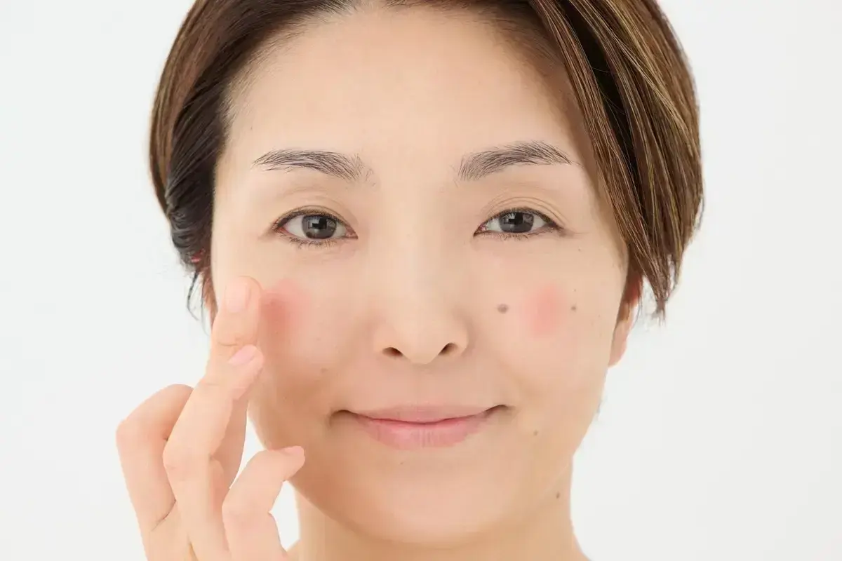 クリームタイプのフェイスカラーをほんの少量取り、黒目の下のやや外側に点で置いて。