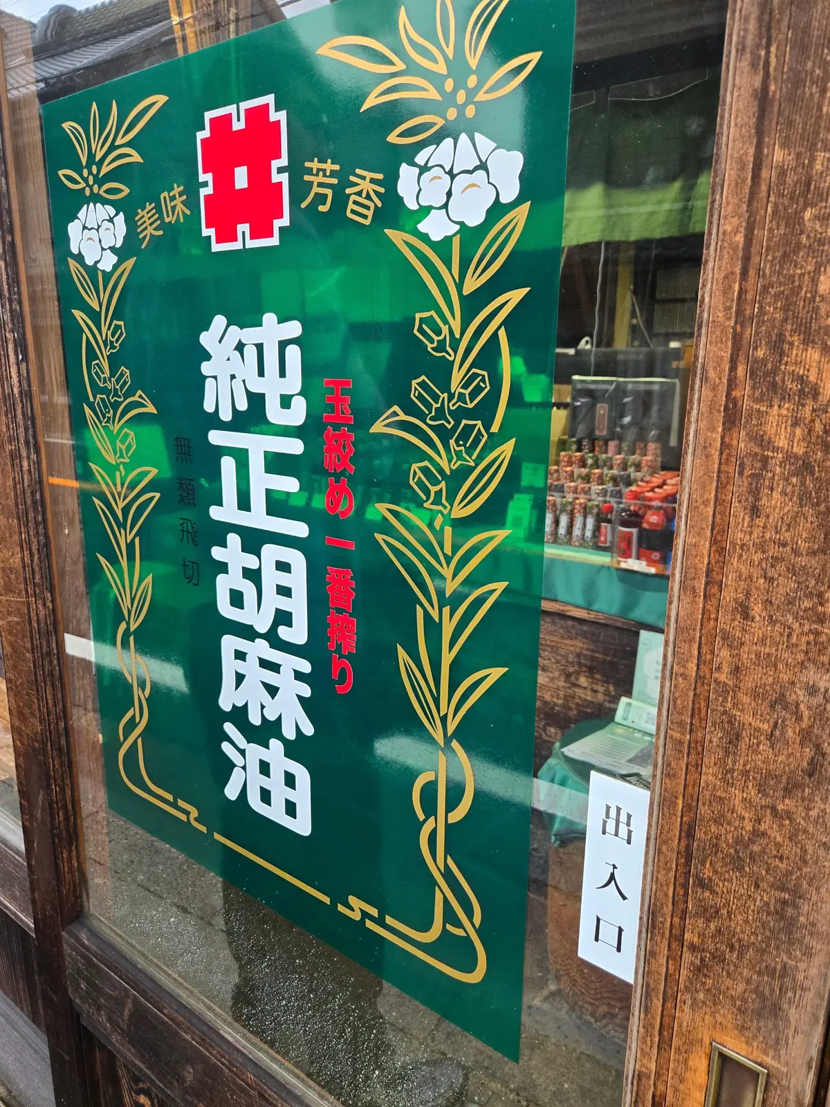 緑の看板に金色の花模様と「中村薬局」の文字が書かれている