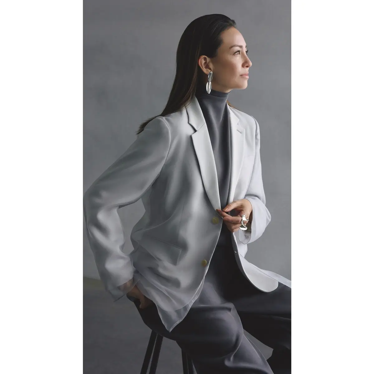 オーガンジーを重ねたライトグレーのテーラーとジャケットにグレーハイネックトップスとグレーパンツを合わせたコーディネート　モデル・RINA